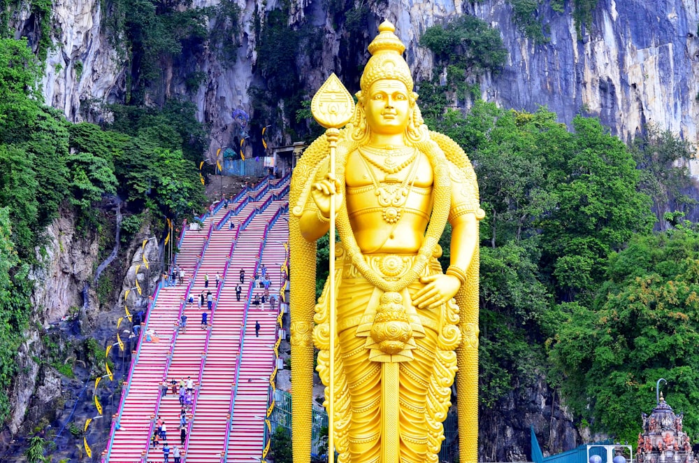 The golden Lord Murugan statue and rainbow steps at Batu Caves, Kuala Lumpur